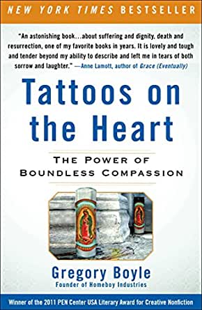 White book cover with the words Tattoos on the Heart in blue and the words The Power of Boundless Compassion in black. Beneath the title is a religous candle depicting or Mary, the Catholic religious figure.